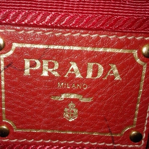 https://dbiyorq10n2b9.cloudfront.net/product-images/CBAGPRA166/PRADA-Vitello-Daino-Large-Shopper-Tote-Red-close-up.jpg.webp